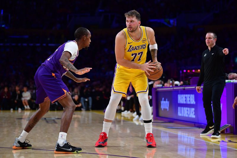 Dec 1, 2025; Los Angeles, California, USA; Los Angeles Lakers guard Luka Doncic (77) controls the ball against Phoenix Suns guard Jamaree Bouyea (17) during the second half at Crypto.com Arena. Mandatory Credit: Gary A. Vasquez-Imagn Images