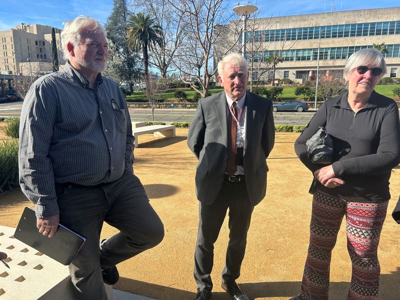 Registrar of Voters Clint Curtis, center, talks to supporters of a ballot measure that would require voter ID after the Thursday, Feb. 26, court hearing.