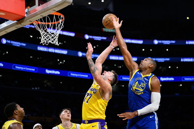 Oct 21, 2025; Los Angeles, California, USA; Golden State Warriors center Al Horford (20) and Los Angeles Lakers guard Luka Doncic (77) jump for the ball during the second half at Crypto.com Arena. Mandatory Credit: William Liang-Imagn Images