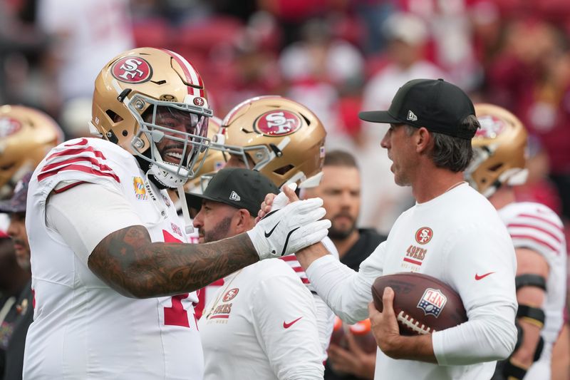 Sep 28, 2025; Santa Clara, California, USA; San Francisco 49ers offensive tackle Trent Williams (left) greets head coach Kyle Shanahan (right) before the game against the Jacksonville Jaguars at Levi's Stadium. Mandatory Credit: Darren Yamashita-Imagn Images