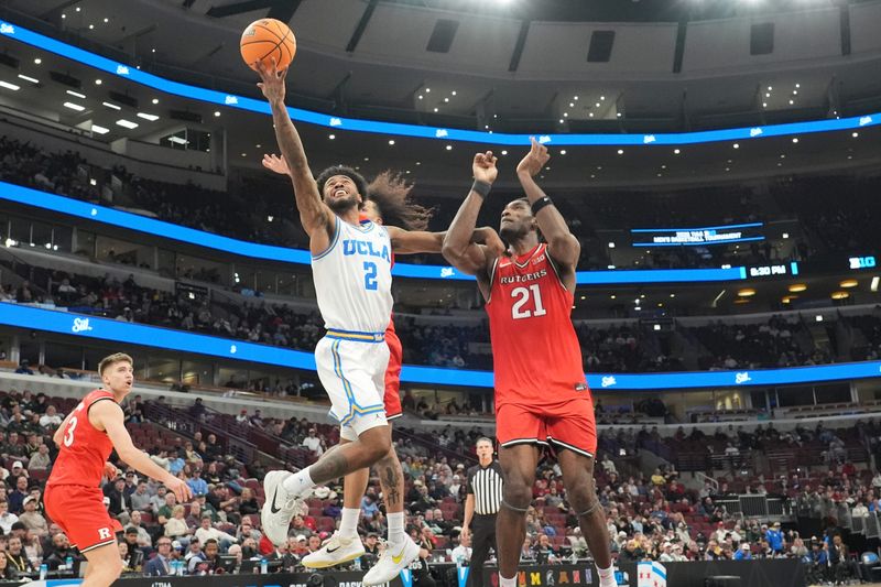 Mar 12, 2026; Chicago, IL, USA; UCLA Bruins guard Donovan Dent (2) scores on Rutgers Scarlet Knights center Emmanuel Ogbole (21) during the first half at United Center. Mandatory Credit: David Banks-Imagn Images