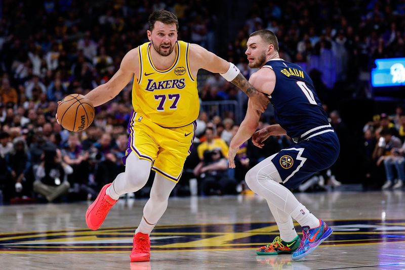 Mar 5, 2026; Denver, Colorado, USA; Los Angeles Lakers guard Luka Doncic (77) controls the ball as Denver Nuggets guard Christian Braun (0) guards in the third quarter at Ball Arena. Mandatory Credit: Isaiah J. Downing-Imagn Images
