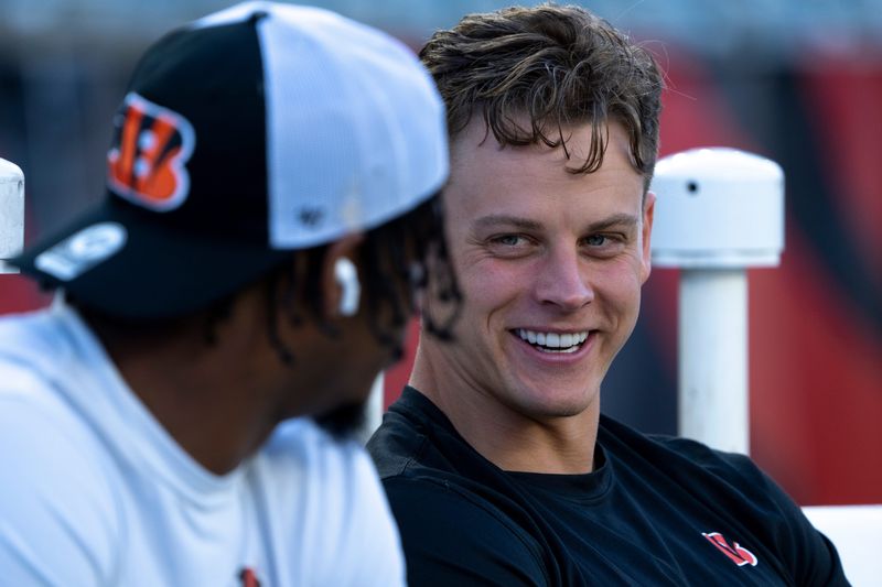 Cincinnati Bengals quarterback Joe Burrow (9) smiles while speaking with Cincinnati Bengals wide receiver Ja'Marr Chase (1) before stretching for the NFL game between the Cincinnati Bengals and Los Angeles Rams at Paycor Stadium in Cincinnati on Monday, Sept. 25, 2023.