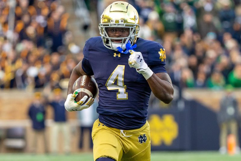 Nov 22, 2025; South Bend, Indiana, USA; Notre Dame Fighting Irish running back Jeremiyah Love (4) runs the ball against the Syracuse Orange during the first half at Notre Dame Stadium. Mandatory Credit: Michael Caterina-Imagn Images