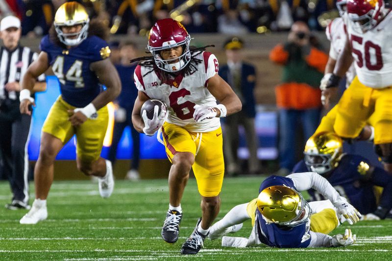 Oct 18, 2025; South Bend, Indiana, USA; Southern California Trojans wide receiver Makai Lemon (6) breaks a tackle by Notre Dame Fighting Irish cornerback Leonard Moore (15) during the first half at Notre Dame Stadium. Mandatory Credit: Michael Caterina-Imagn Images