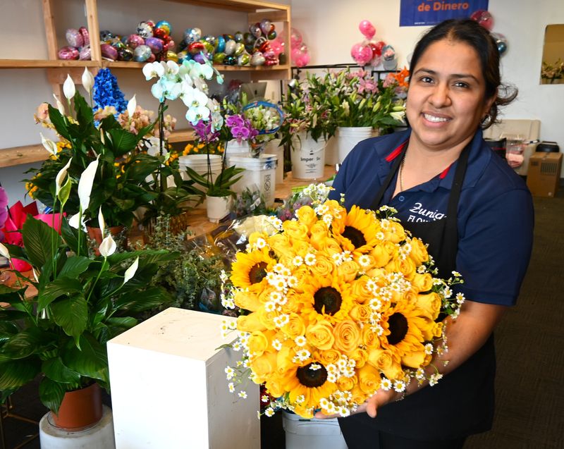 Josefina Zuniga holds a floral arrangement inside her new shop, Zuniga Flowers, located in Adelanto. Zuniga Flowers opened its doors in the Adelanto Marketplace shopping center last month.
