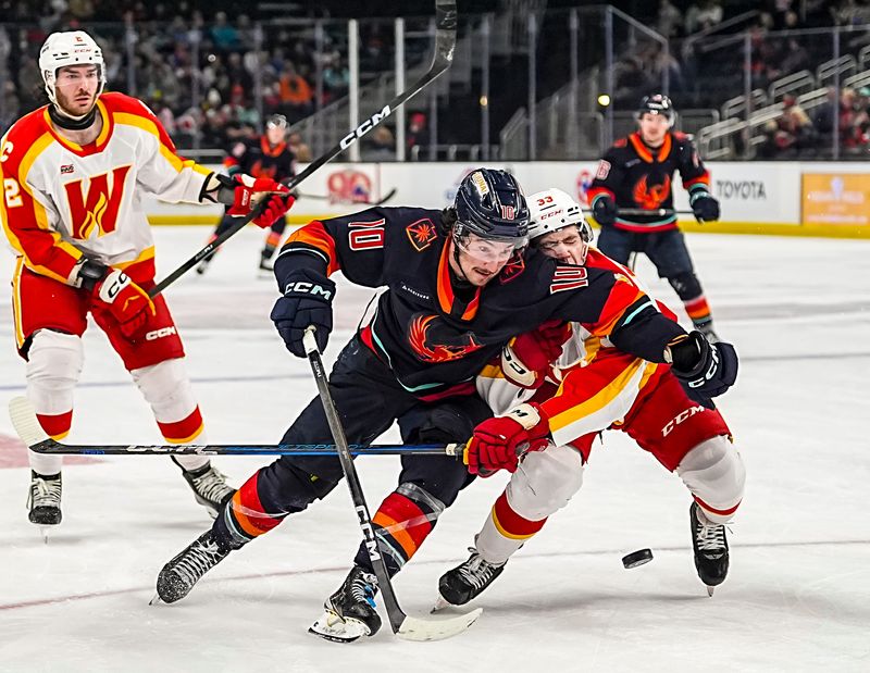 Coachella Valley Firebirds forward J.R. Avon collides with 

as he chases down the puck during the third period of their game at Acrisure Arena in Palm Desert, Calif., Wednesday, March 25, 2026.