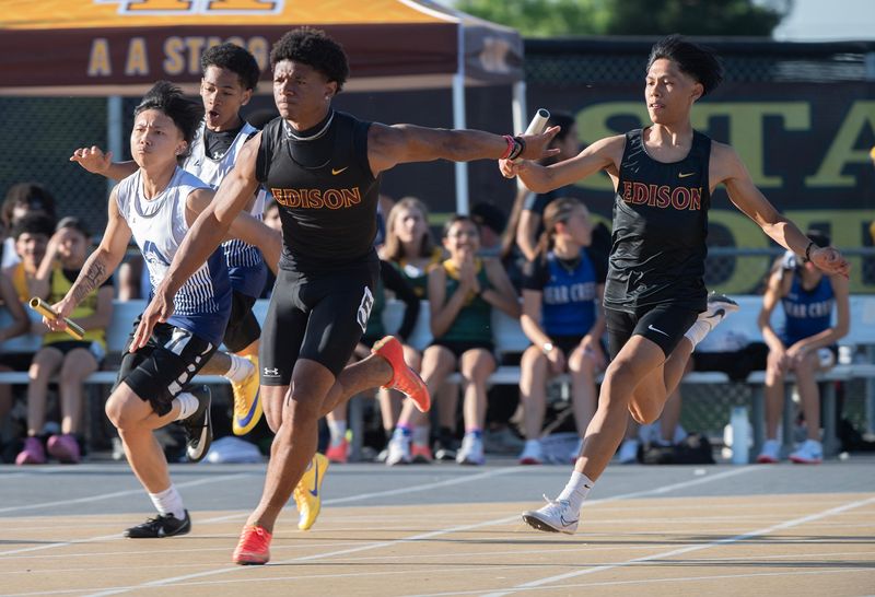 Edison’s Travis Gresham, left, receives the baton from teammate Kailan Beaver In the boys 4x100 relay during the 23rd Stockton All City Track Meet at Stagg High School in Stockton on Mar. 27, 2026.