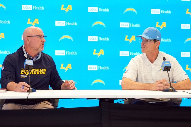 Jan 15, 2026; El Segundo, CA, USA; Los Angeles Chargers general manager Joe Hortiz (left) and coach Jim Harbaugh at press conference at The Bolt. Mandatory Credit: Kirby Lee-Imagn Images