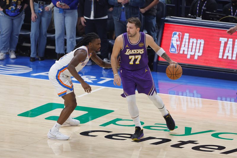 Nov 12, 2025; Oklahoma City, Oklahoma, USA; Los Angeles Lakers guard Luka Doncic (77) moves the ball as Oklahoma City Thunder guard Isaiah Joe (11) defends during the first quarter at Paycom Center. Mandatory Credit: Alonzo Adams-Imagn Images