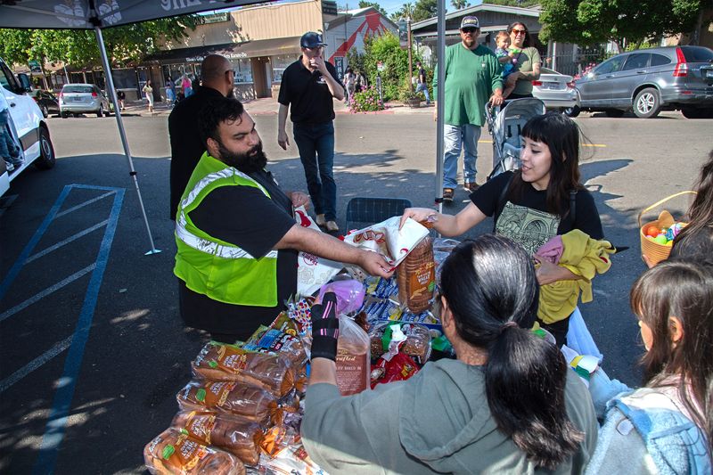 The Bread of Life gives out free food at the Yosemite Street Village egg hunt in midtown Stockton on Apr. 4, 2026. Dozens of children search for about 4,500 plastic eggs filled with candy and stickers at the annual event.