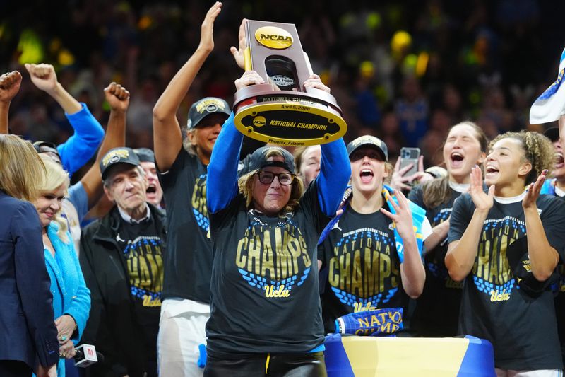 Apr 5, 2026; Phoenix, AZ, USA; UCLA Bruins head coach Cori Close celebrates with the trophy on the podium after defeating the South Carolina Gamecocks in the National Championship game of the women's 2026 NCAA Tournament at Mortgage Matchup Center. Mandatory Credit: Kirby Lee-Imagn Images