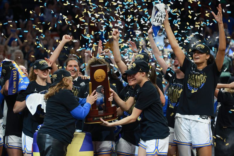 Apr 5, 2026; Phoenix, AZ, USA; UCLA Bruins head coach Cori Close hands the trophy to her players after the National Championship game against the South Carolina Gamecocks of the women's 2026 NCAA Tournament at Mortgage Matchup Center. Mandatory Credit: Mark J. Rebilas-Imagn Images