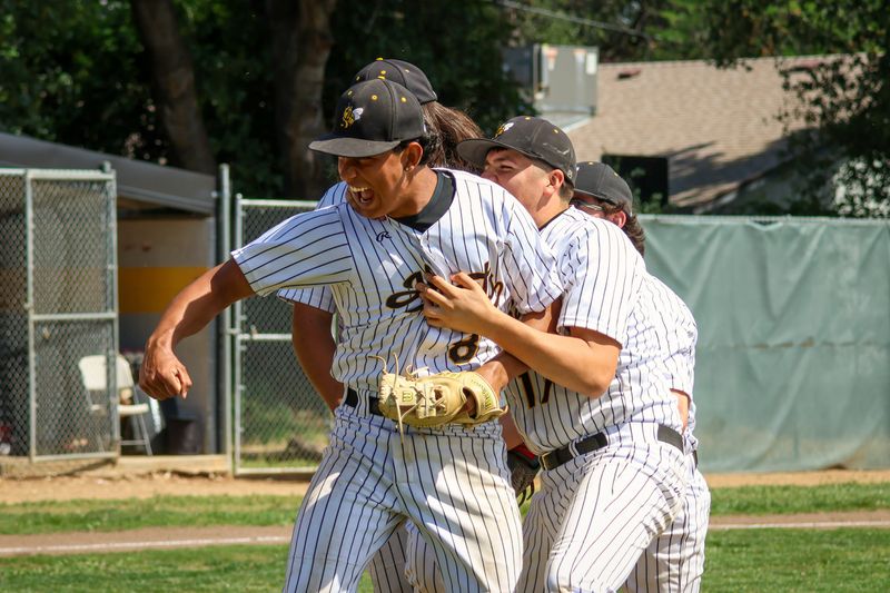 Enterprise baseball players storm the mound and mob junior Wayde Hutchings (middle). Hutchings set down the last four batters in Enterprise's combined no-hitter against Foothill on Tuesday, April 7, 2026.