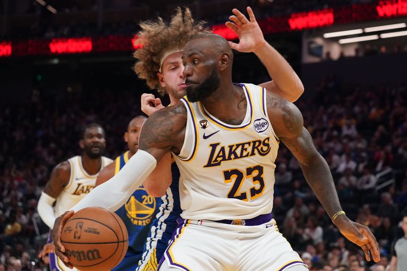 Feb 28, 2026; San Francisco, California, USA; Los Angeles Lakers forward LeBron James (23) dribbles against Golden State Warriors guard Brandin Podziemski (2) in the second period at Chase Center. Mandatory Credit: David Gonzales-Imagn Images