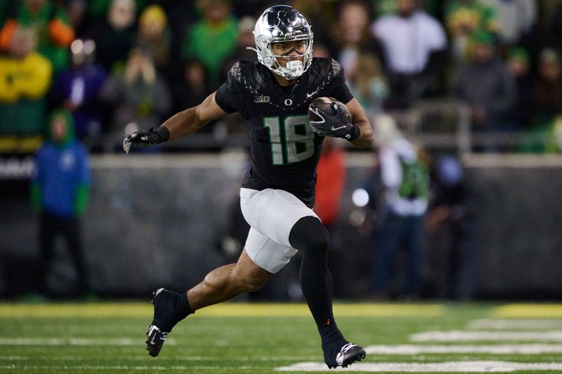 Nov 30, 2024; Eugene, Oregon, USA; Oregon Ducks tight end Kenyon Sadiq (18) carries the ball during the second half against the Washington Huskies at Autzen Stadium. Mandatory Credit: Troy Wayrynen-Imagn Images