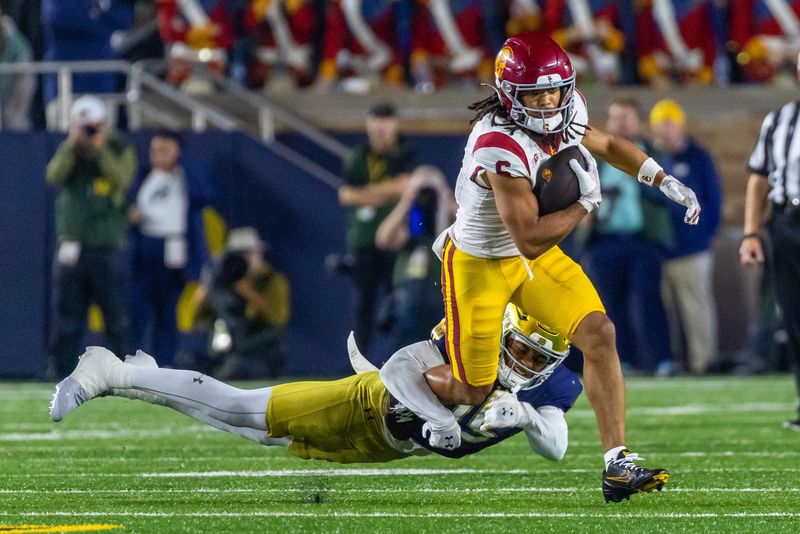 Oct 18, 2025; South Bend, Indiana, USA; Southern California Trojans wide receiver Makai Lemon (6) tries to break a tackle by Notre Dame Fighting Irish cornerback Leonard Moore (15) during the first half at Notre Dame Stadium. Mandatory Credit: Michael Caterina-Imagn Images