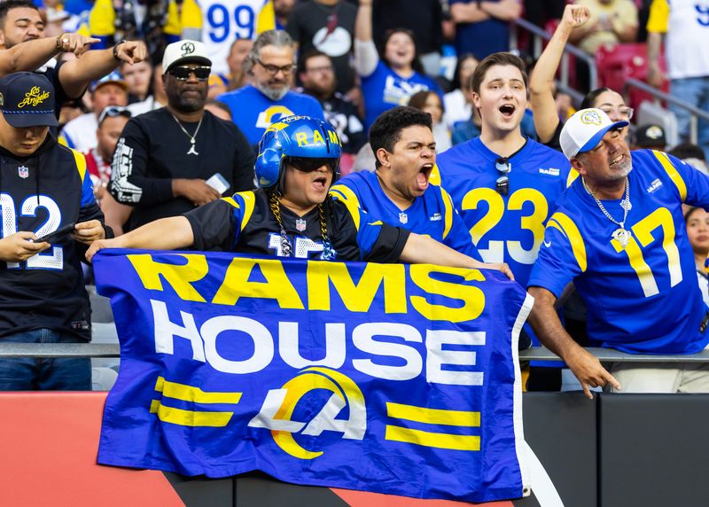 Dec 7, 2025; Glendale, Arizona, USA; Los Angeles Rams fans in the crowd celebrate a touchdown against the Arizona Cardinals during the second half at State Farm Stadium. Mandatory Credit: Mark J. Rebilas-Imagn Images