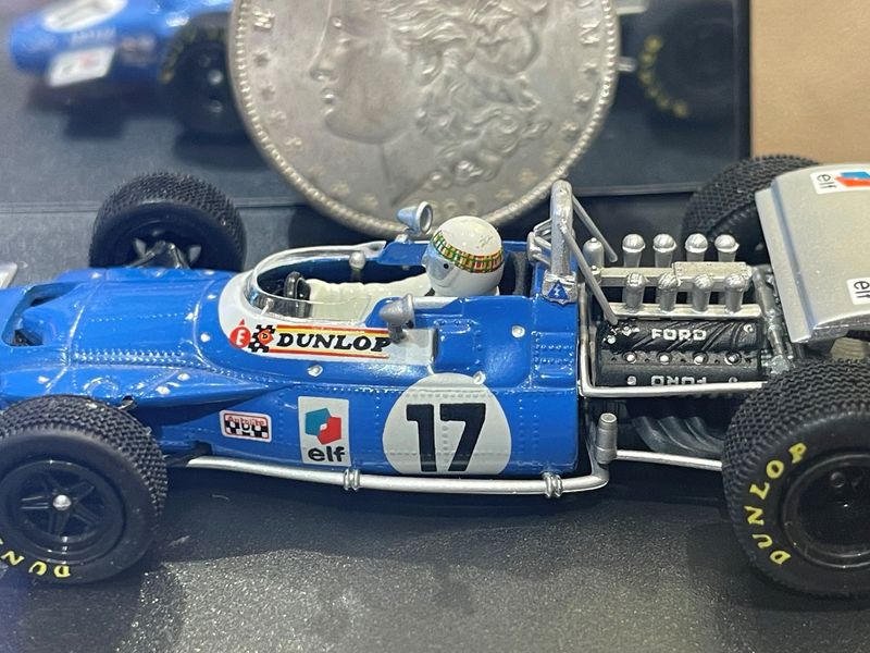 This tiny Formula One model car shows great detail yet is dwarfed by the silver dollar in the background.