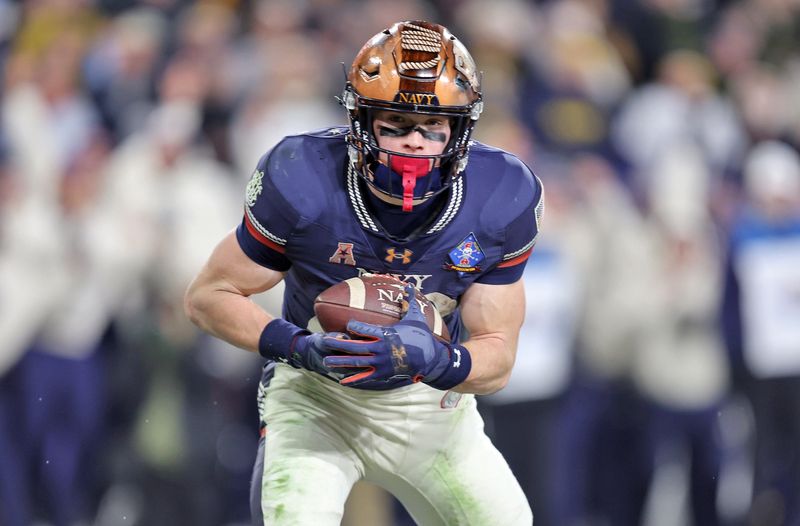 Dec 13, 2025; Baltimore, Maryland, USA; Navy Midshipmen slotback Eli Heidenreich (22) catches a pass for a touchdown against the Army Black Knights during the second half of the 126th Army-Navy game at M&T Bank Stadium. Mandatory Credit: Danny Wild-Imagn Images