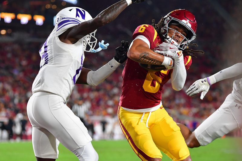 Nov 7, 2025; Los Angeles, California, USA; Southern California Trojans wide receiver Makai Lemon (6) scores a touchdown against Northwestern Wildcats defensive back Josh Fussell (13) during the first half at the Los Angeles Memorial Coliseum. Mandatory Credit: Gary A. Vasquez-Imagn Images