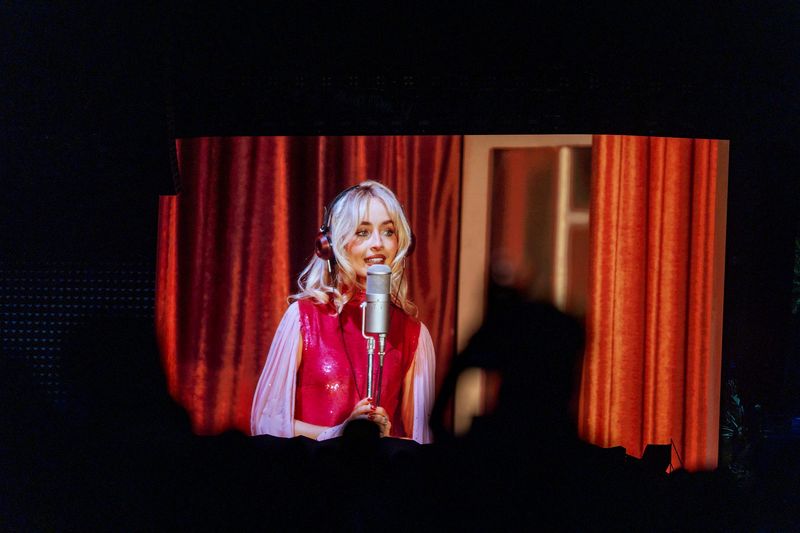 Sabrina Carpenter performs on the Coachella Stage as seen on the big screens at the Coachella Valley Music and Arts Festival in Indio, Calif., on Friday, April 17, 2026.