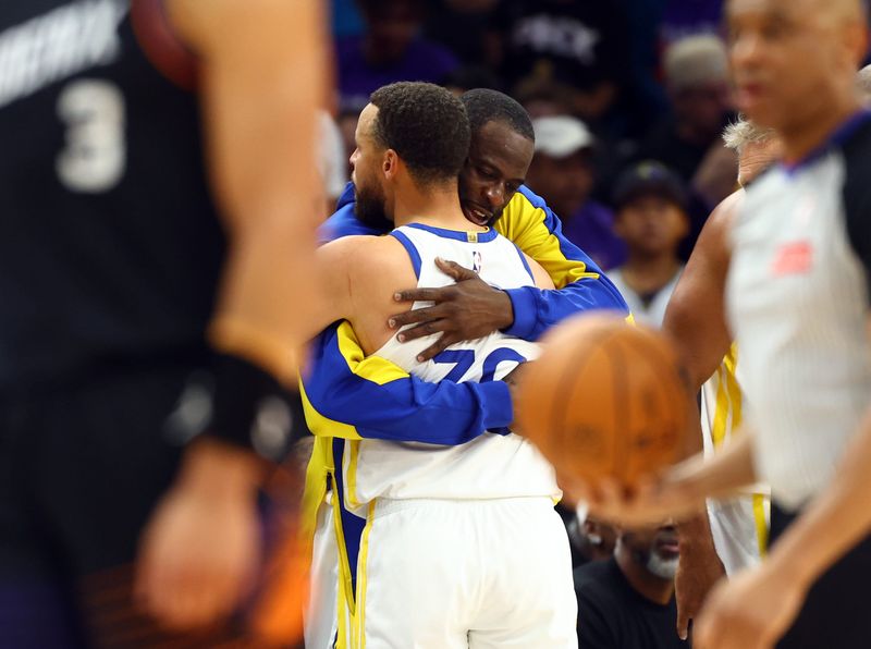 Apr 17, 2026; Phoenix, Arizona, USA; Golden State Warriors guard Stephen Curry (30) hugs forward Draymond Green against the Phoenix Suns during the closing seconds of the play-in rounds of the 2026 NBA Playoffs at Mortgage Matchup Center. Mandatory Credit: Mark J. Rebilas-Imagn Images