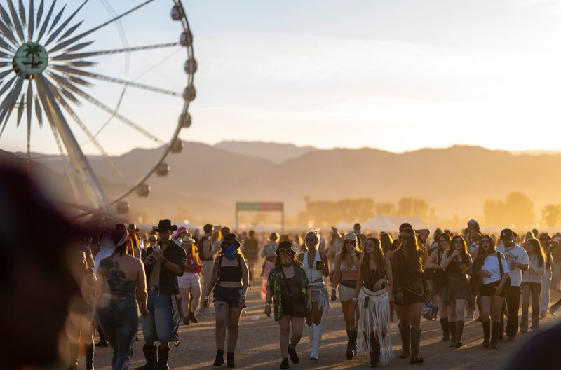 Festivalgoers walk toward the main stage area as the sun sets during Weekend 2 of the Coachella Valley Music and Arts Festival in Indio, Calif., Saturday, April 18, 2026.