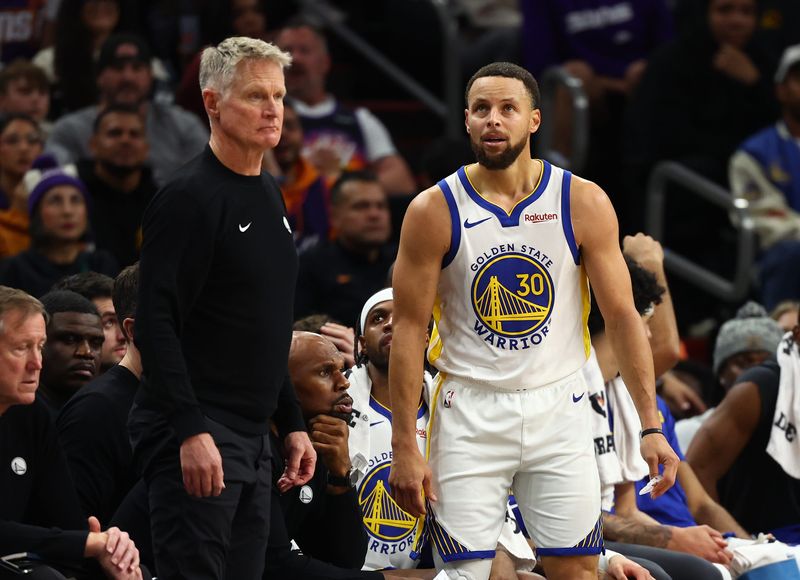 Dec 18, 2025; Phoenix, Arizona, USA; Golden State Warriors guard Stephen Curry (30) reacts alongside head coach Steve Kerr against the Phoenix Suns in the second half at Mortgage Matchup Center. Mandatory Credit: Mark J. Rebilas-Imagn Images
