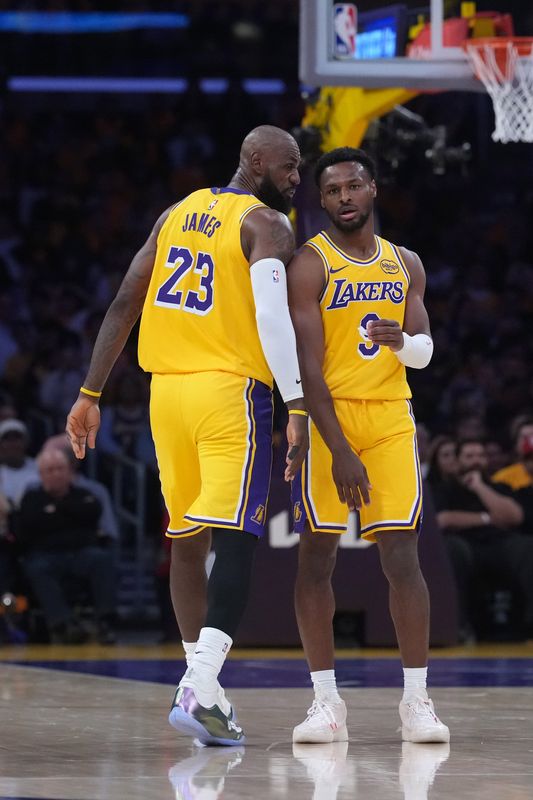 Apr 18, 2026; Los Angeles, California, USA; Los Angeles Lakers forward LeBron James (23) talks with son Bronny James (9) in the first half against the Houston Rockets during game one of the first round of the 2026 NBA Playoffs at Crypto.com Arena. Mandatory Credit: Kirby Lee-Imagn Images