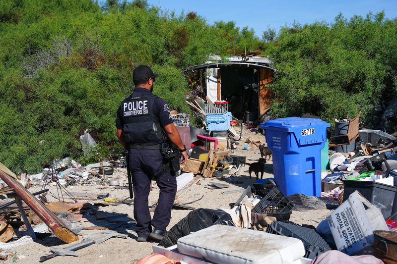 Desert Hot Springs police Cpl. Gustavo Ramirez makes contact with people living amongst the well-hidden mesquite-covered sand dunes. Ramirez is part of a police homelessness outreach team.