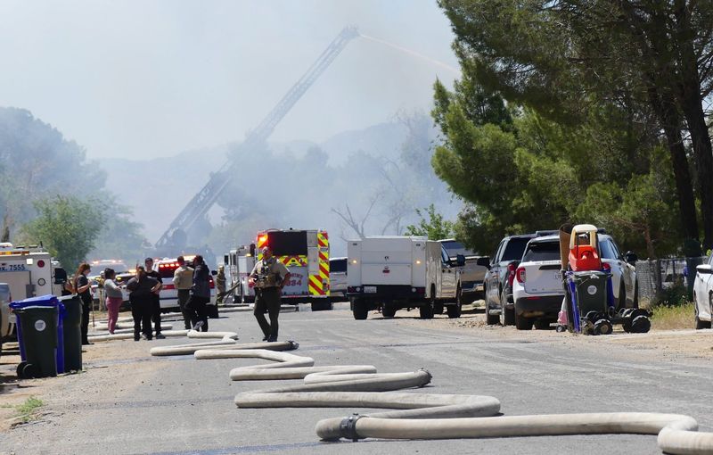 Police and fire personnel responded after a woman allegedly stabbed a man before setting fire to a home and barricading herself inside in the 15900 block of Washoan Road in Apple Valley on Friday, April 24, 2026.