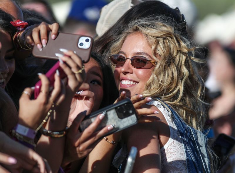 Sydney Sweeney takes photos with the front row fans just before BigXthePlug performed on the Mustang Stage during the Stagecoach Festival in Indio, Calif., April 24, 2026.