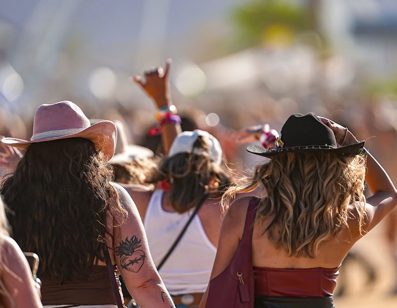 Festivalgoers hold onto their hats as the wind picks up during Stagecoach Music Festival in Indio, Calif., Friday, April 24, 2026.