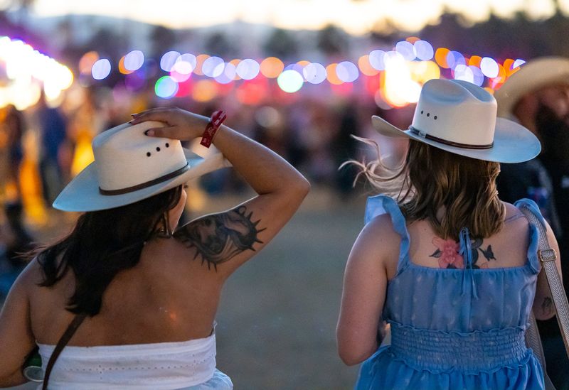 Festivalgoers hold onto their hats as the wind picks up during Stagecoach Music Festival in Indio, Calif., Friday, April 24, 2026.