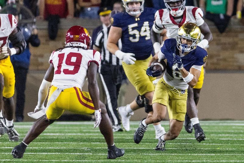 Oct 18, 2025; South Bend, Indiana, USA; Notre Dame Fighting Irish wide receiver Jordan Faison (6) runs with the ball while Southern California Trojans safety Bishop Fitzgerald (19) defends in the first half at Notre Dame Stadium. Mandatory Credit: Trevor Ruszkowski-Imagn Images