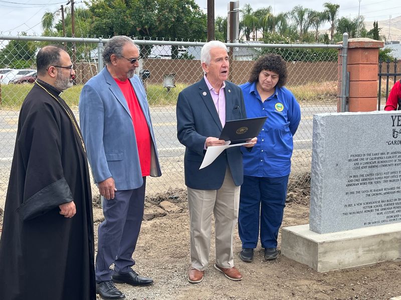 U.S. Congressman Jim Costa reads the certificate of congressional recognition as Rev. Father Mashdots Keshishian, event organizer Chuck Simonian, and Tulare County Supervisors Board Chair Amy Shuklian look on.