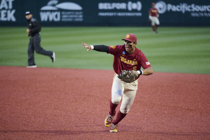 May 31, 2025; Corvallis, OR, USA; USC infielder Adrian Lopez (5) waves off a teammate as he tags first base during the ninth inning against Saint Mary's at Goss Stadium. Mandatory Credit: Troy Wayrynen-Imagn Images