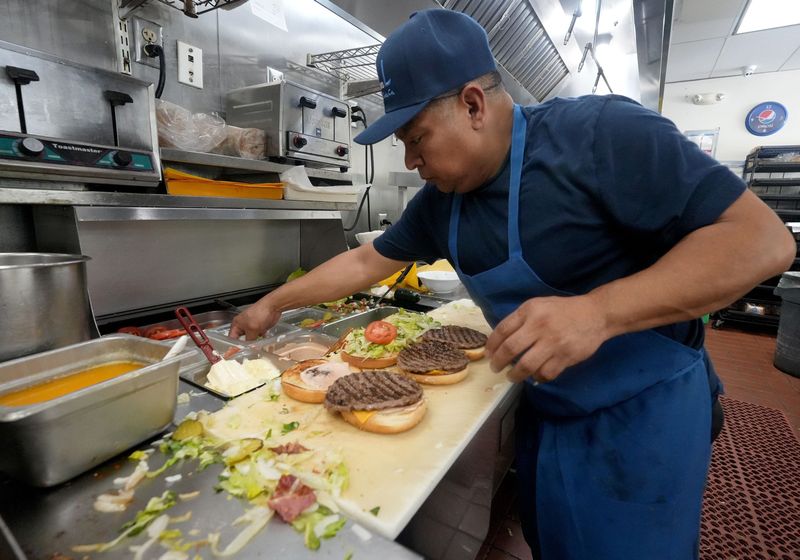 Jesus Orozco, a cook at P&L Burgers in Thousand Oaks, prepares bacon cheeseburgers on April 29, 2026.