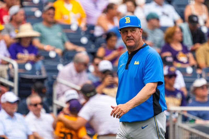 Jun 16, 2025; Omaha, Neb, USA; UCLA Bruins head coach John Savage walks off the field before the game against the LSU Tigers at Charles Schwab Field. Mandatory Credit: Dylan Widger-Imagn Images