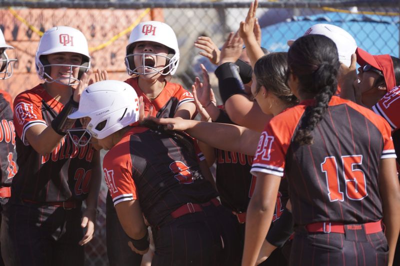 Oak Hills' Sienna Garcia, center, is greeted by teammates at the plate after hitting a home run against Apple Valley on Friday, May 1, 2026. Oak Hills beat Apple Valley 15-5 to claim a share of the Mojave River League title.