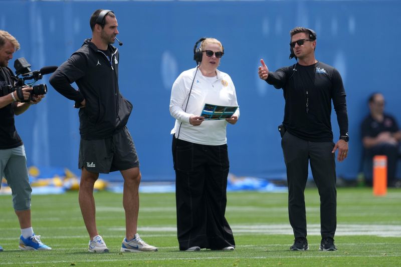 May 2, 2026; Pasadena, CA, USA; UCLA Bruins women's basketball coach Cori Close (center) calls plays with offensive coordinator Dean Kennedy (left) and coach Bob Chesney during the spring game at Rose Bowl. Mandatory Credit: Kirby Lee-Imagn Images