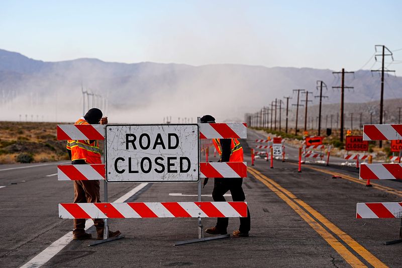 Palm Springs city employees secure road closed signs to North Indian Canyon Drive in Palm Springs, Calif., on Sunday, May 3, 2026.