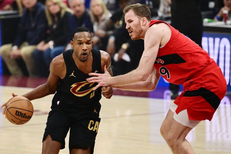 May 3, 2026; Cleveland, Ohio, USA; Cleveland Cavaliers center Evan Mobley (4) drives to the basket against Toronto Raptors center Jakob Poeltl (19) during the first quarter of game seven in the first round of the 2026 NBA Playoffs at Rocket Arena. Mandatory Credit: Ken Blaze-Imagn Images