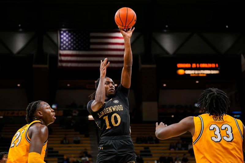 Nov 27, 2024; Columbia, Missouri, USA; Lindenwood Lions guard Jadis Jones (10) shoots the ball against Missouri Tigers guard Mark Mitchell (25) and center Josh Gray (33) during the first half at Mizzou Arena. Mandatory Credit: Jay Biggerstaff-Imagn Images