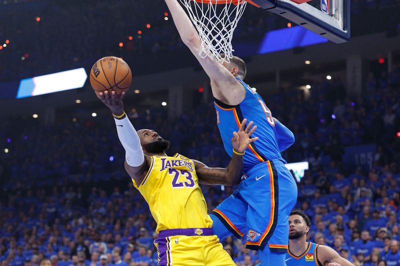May 5, 2026; Oklahoma City, Oklahoma, USA; Los Angeles Lakers forward LeBron James (23) goes up for a basket as Oklahoma City Thunder center Isaiah Hartenstein (55) defends in the first half during game one of the second round of the 2026 NBA Playoffs at Paycom Center. Mandatory Credit: Alonzo Adams-Imagn Images