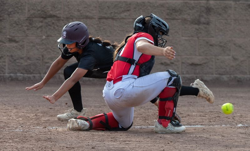 St. Mary’s Mckenzie Abriol, left, dives to home play to score a run as Lincoln’s Mallory Wagner waits for the throw during a varsity softball game at Arnaiz Stadium in Stockton on May 5, 2026. St. Mary’s won 6-4.