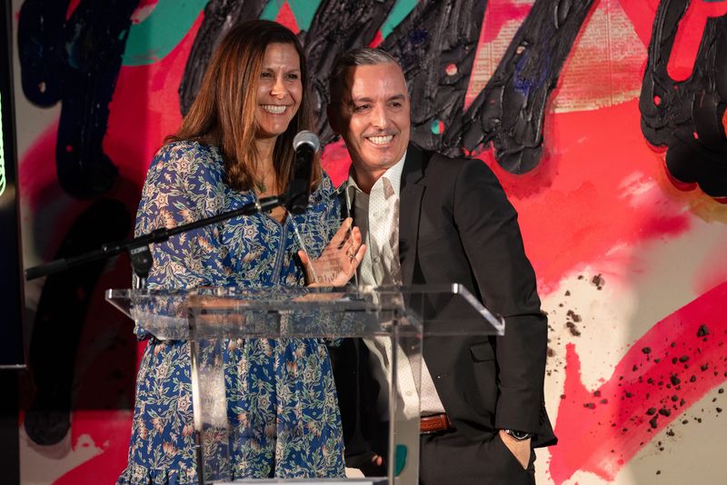 Dr. Lindsey Valenzuela, with Rob Wheeler, accepts the honoree award on behalf of Desert Oasis Healthcare and its 45th anniversary.
