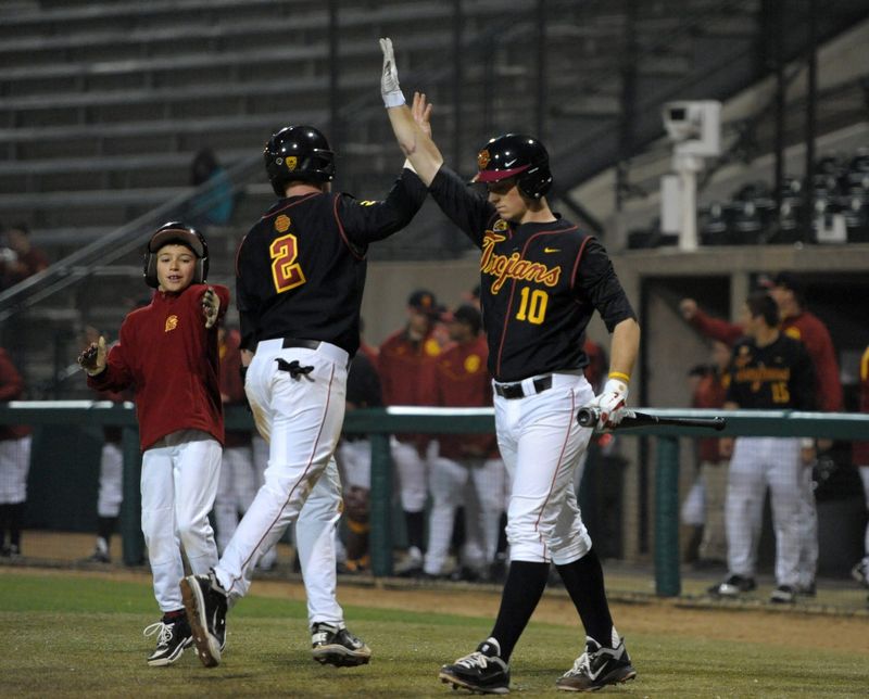 Feb 24, 2012; Los Angeles, CA, USA; Southern California Trojans infielder Adam Landecker (2) is congratulated by catcher Kevin Roundtree (10) after scoring against the Akron Zips at Dedeaux Field. USC defeated Akron 12-1. Mandatory Credit: Kirby Lee/Image of Sport-USA TODAY Sports