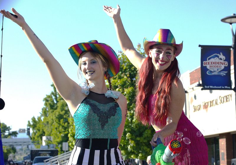 Stilt walkers Ember Smith, left, and Jordan Valenzuela pose for a photo during the Asphalt Cowboys Street Dance, which took place Friday, May 8, 2026, on the Market Street Promenade in downtown Redding to help kick off the annual rodeo season.